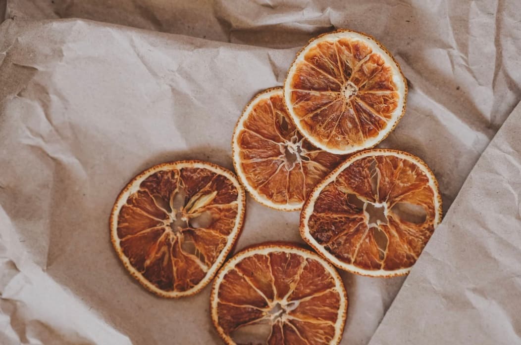 Tranches d'orange séchées posées sur du papier kraft froissé
